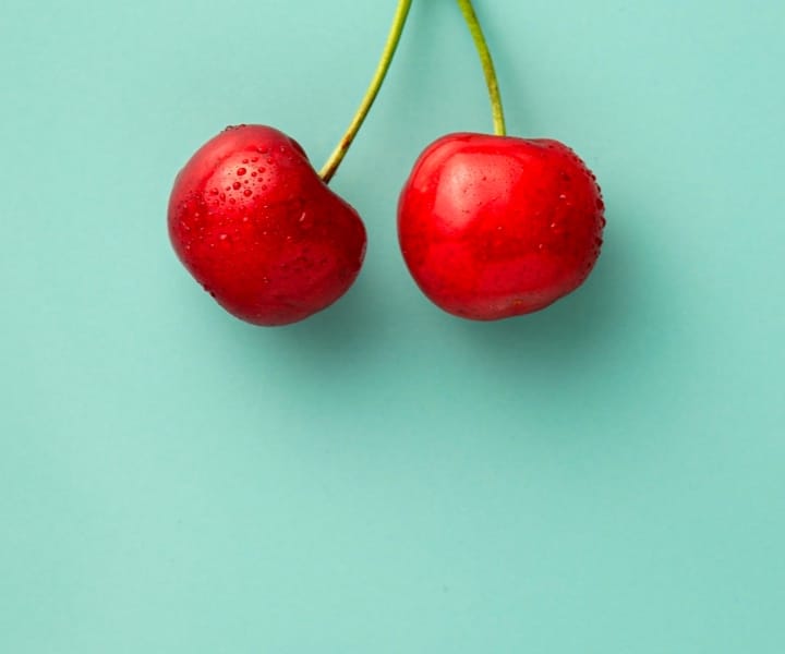 Cherries on green background